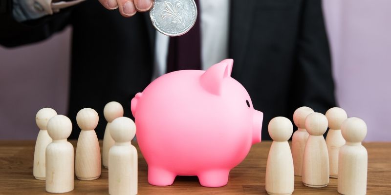 Um empregador pagando dinheiro em um cofrinho no local de trabalho ou plano de previdência privada